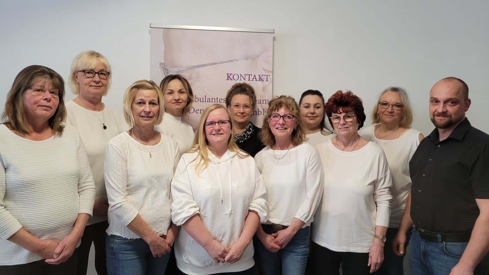 Das Team des Ambulanten Pflegeteams Denny Schulz vor der Kontaktwand